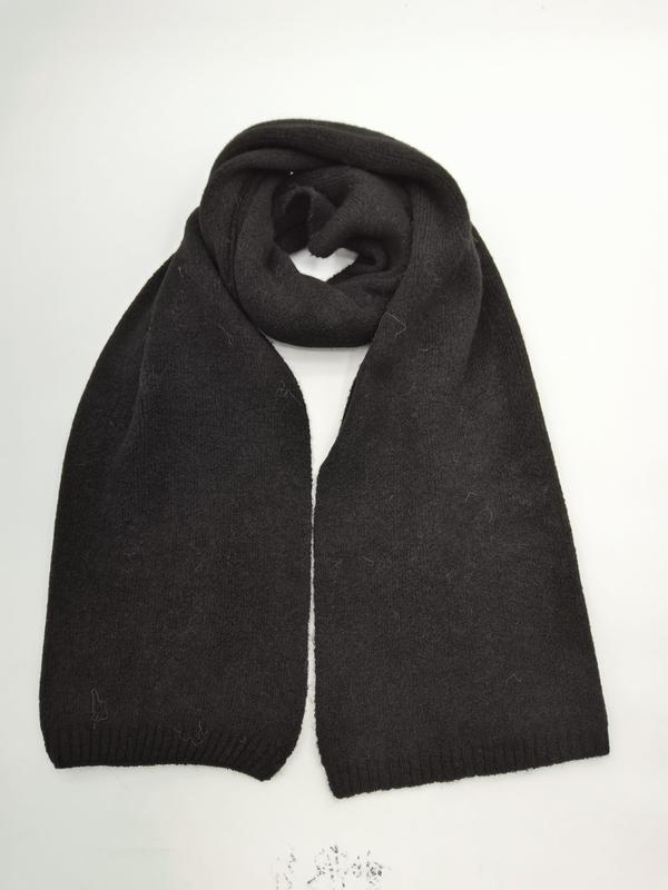 Black chunky knit winter scarf folded in loop shape with ribbed edges, laid flat on white background