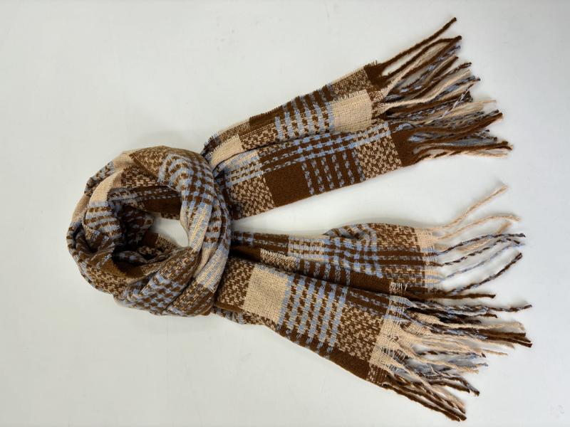 Woven plaid scarf in brown, blue, and cream with fringe ends, loosely knotted on white background