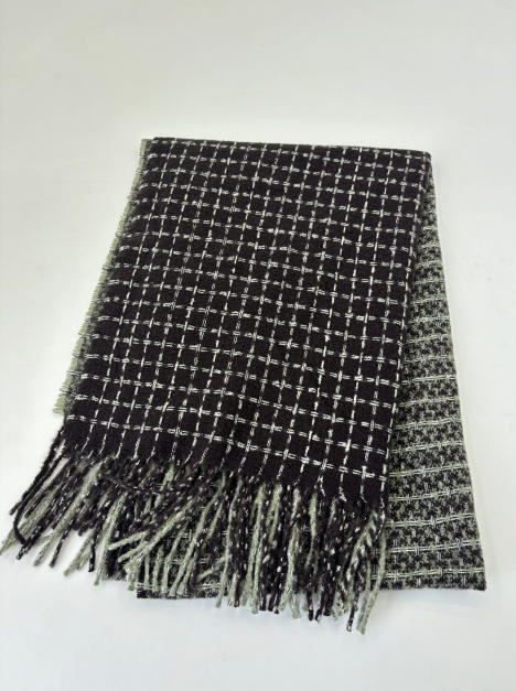 Folded black and white woven check pattern throw blanket with fringe trim, reversible houndstooth design
