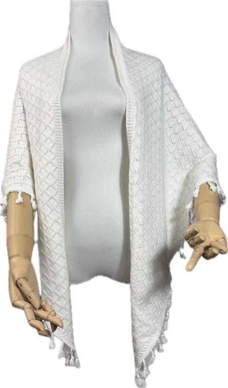 White diamond-pattern knit open-front cardigan wrap with tassel fringe hem and sleeves displayed on mannequin