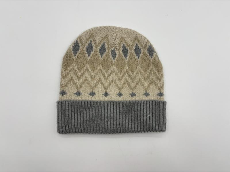 Beige knit beanie hat with grey Fair Isle diamond and chevron pattern and grey ribbed cuff, flat lay on white background