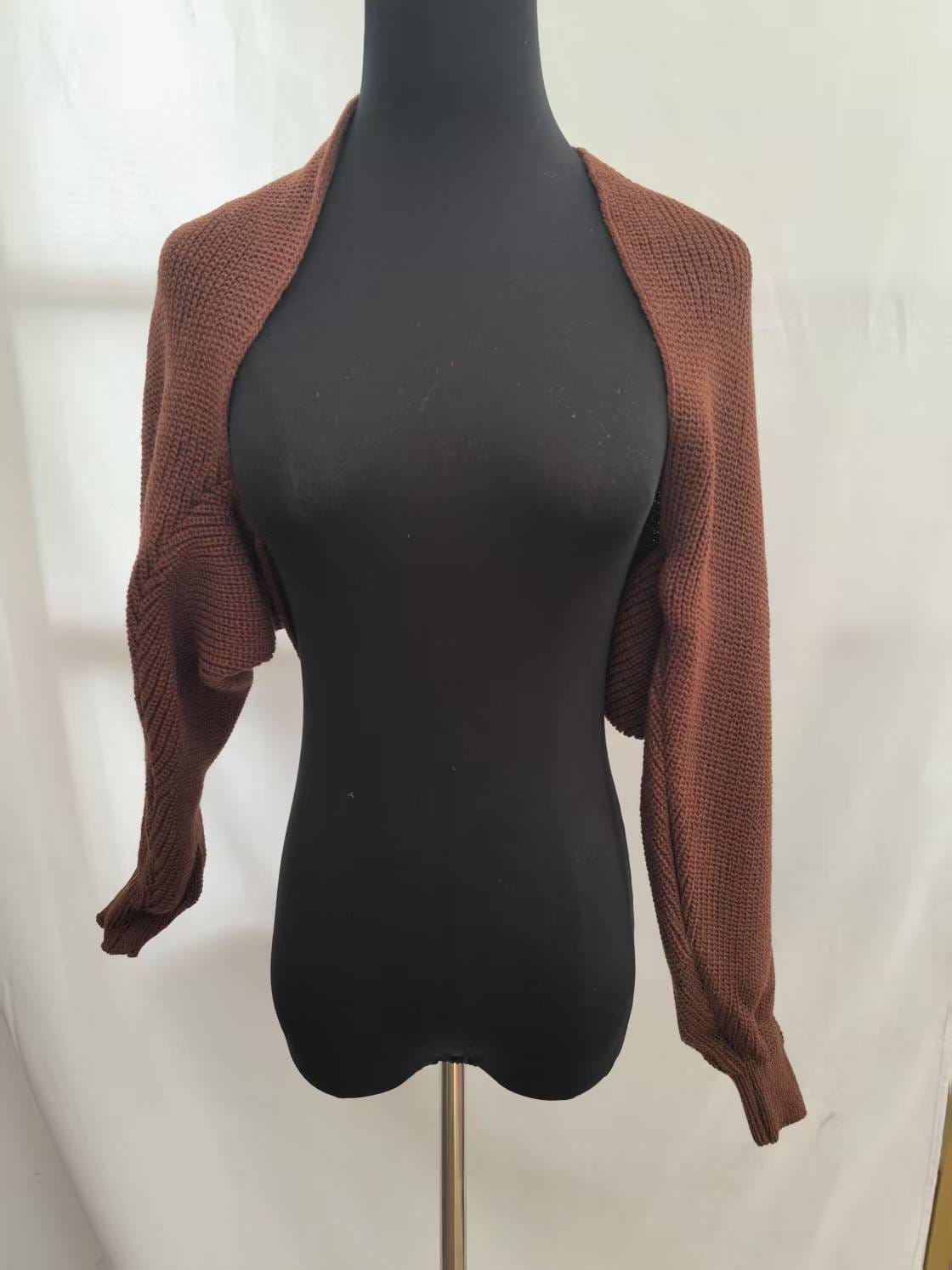 Brown chunky knit cropped bolero shrug cardigan with long sleeves displayed on a black mannequin against white background