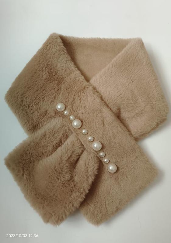 Soft camel faux fur crossover neck scarf decorated with a diagonal row of mixed-size pearl buttons on white background