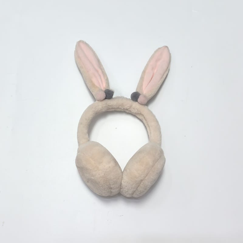 Beige fluffy faux fur earmuffs with soft headband on white background, cozy winter ear warmers