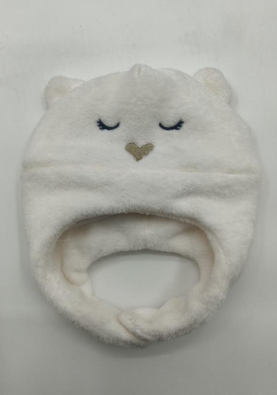 Soft white fleece infant hat shaped like a bear with embroidered closed eyes, gold heart nose, and small ears