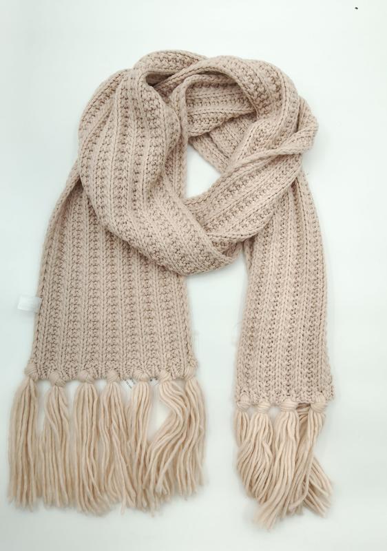 Blush beige chunky ribbed knit winter scarf with large tassel fringe ends, loosely draped on white background