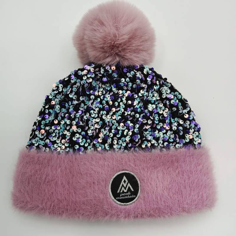 Pink winter beanie hat with iridescent sequin body, fluffy faux fur pink cuff and oversized pom-pom on white background