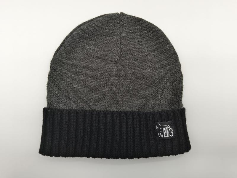 Grey knit beanie hat with black ribbed cuff and New York 93 woven label on white background