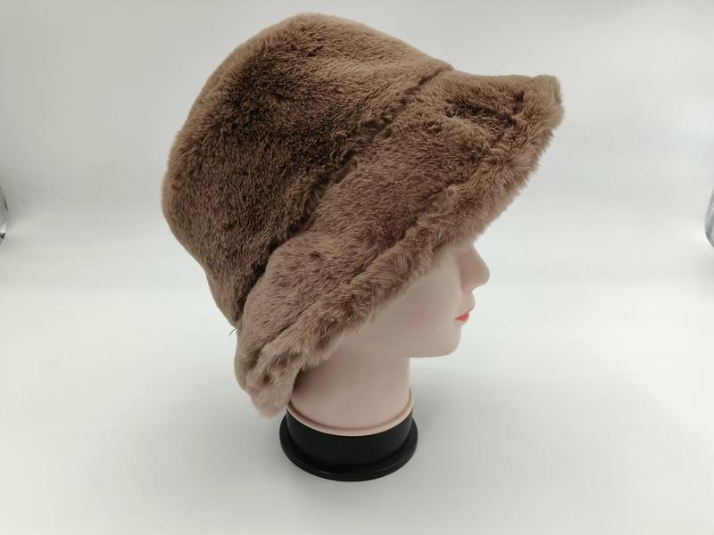 Taupe brown faux fur bucket hat displayed on a mannequin head, side view showing soft fluffy texture and wide brim