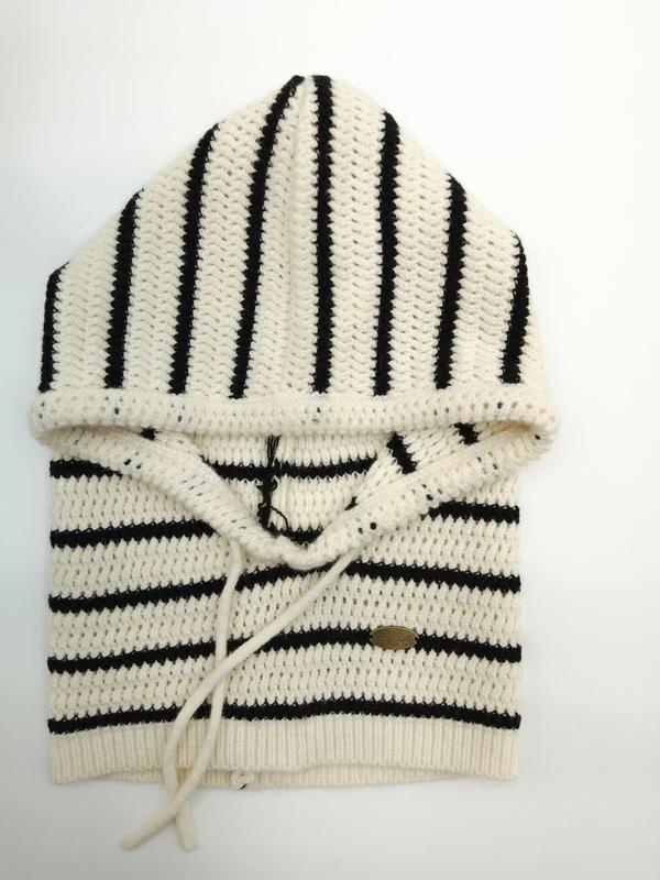 Folded cream and black striped crochet knit hoodie sweater with drawstring hood and ribbed hem, displayed flat on white background