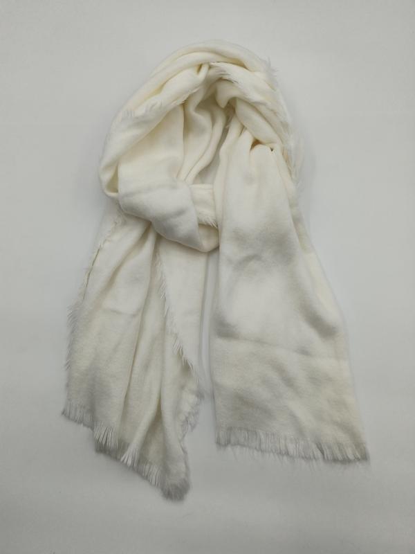 Ivory cream lightweight wrap scarf with fringe hem, loosely draped and knotted on white background