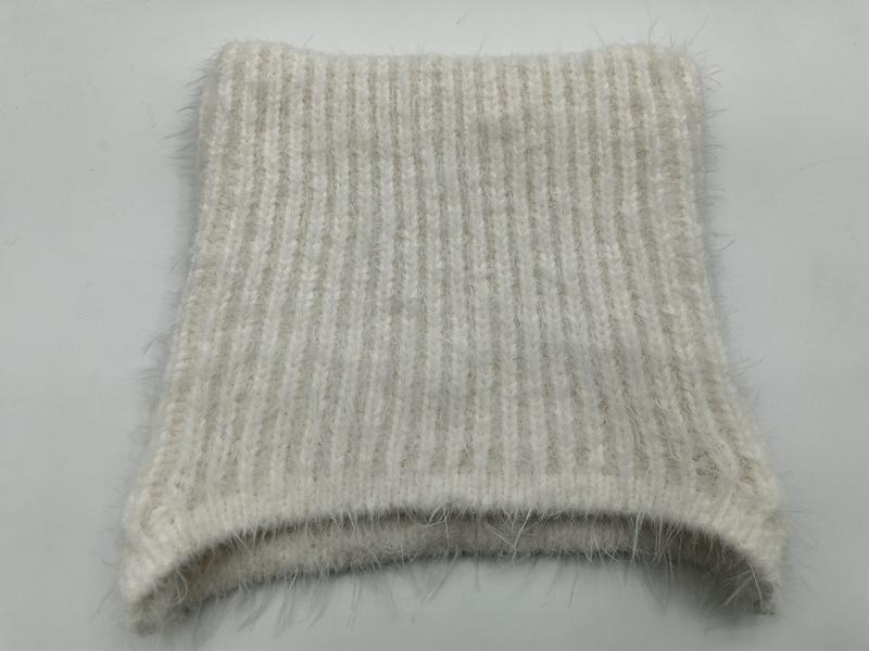 Close-up of a cream and beige ribbed knit fabric swatch with soft mohair halo texture, folded flat on white background