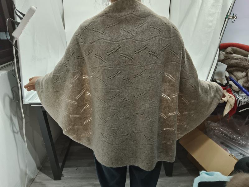 Back view of a woman wearing an oversized beige pointelle knit cardigan with batwing sleeves and wave lace pattern