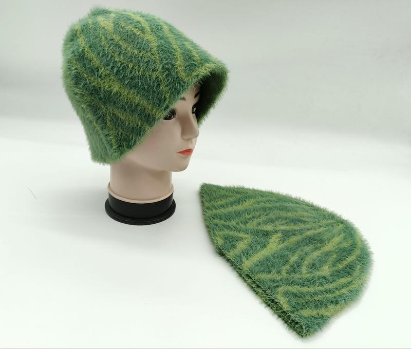 Green fuzzy knit beanie hat with yellow-green leaf stripe pattern shown on mannequin head and laid flat on white background