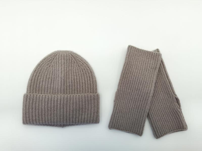 Taupe ribbed knit winter beanie hat and matching fingerless gloves set laid flat on white background