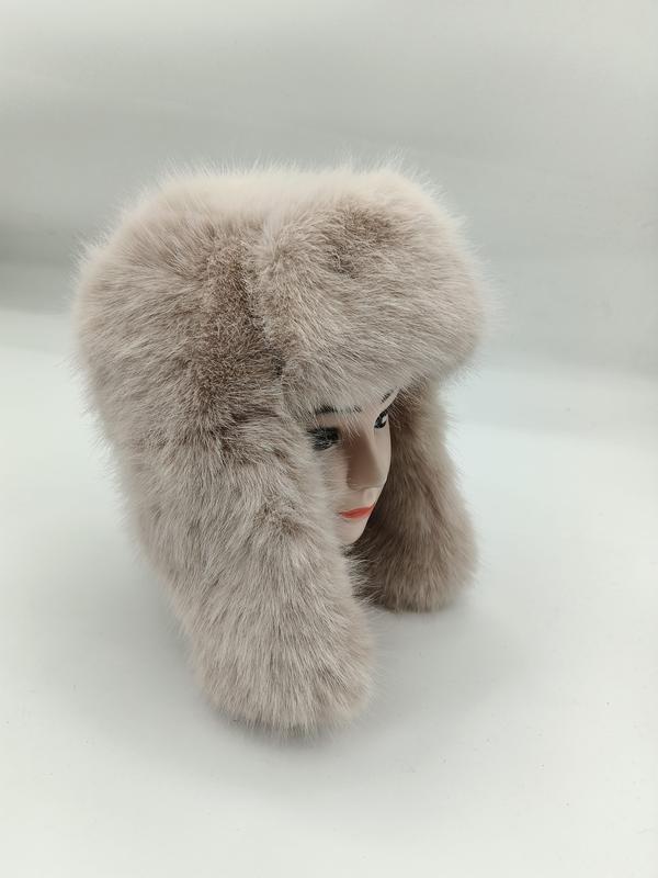 Fluffy beige faux fur trapper ushanka hat with long ear flaps displayed on a mannequin head against white background