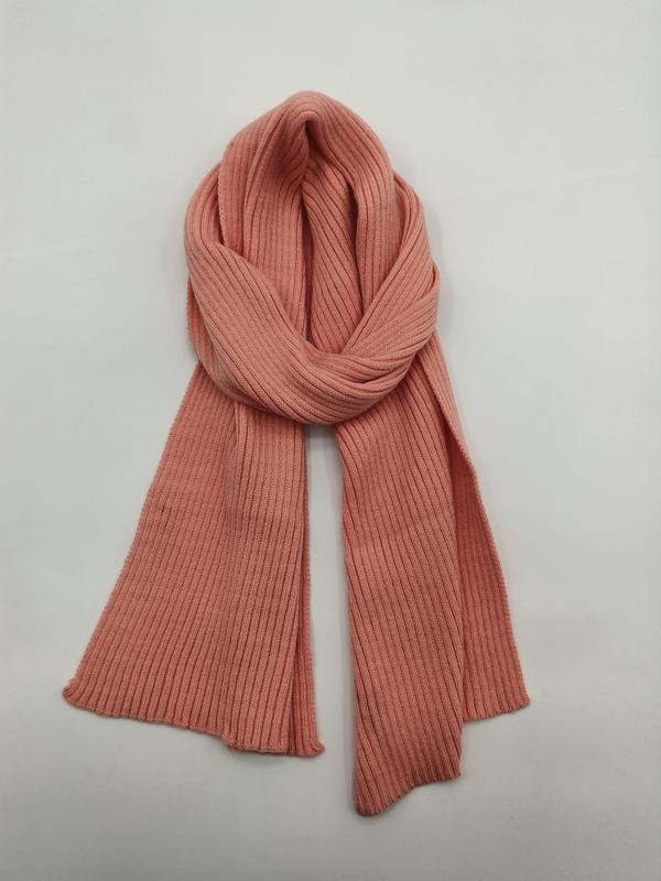 Dusty rose pink ribbed knit scarf loosely wrapped on white background, showing fine rib texture and soft drape