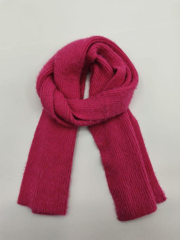 Fuchsia pink ribbed knit scarf folded in a loop on white background, soft fuzzy textured yarn