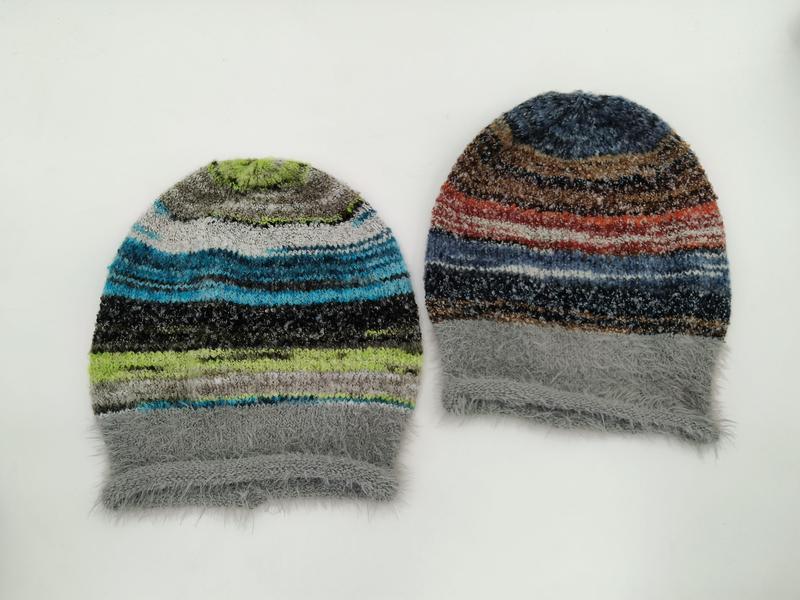 Two multicolor striped fuzzy knit beanie hats laid flat, one in blue-green tones and one in red-brown tones, both with gray fluffy cuffs