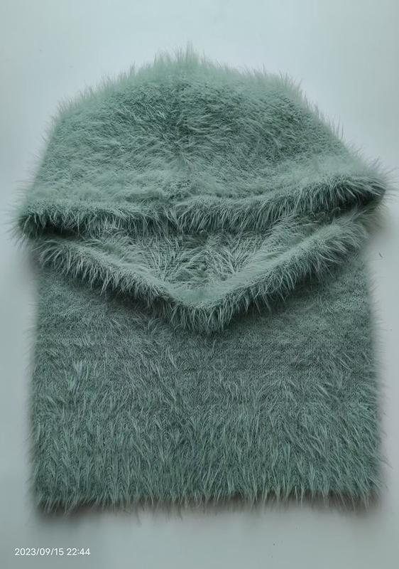 Folded mint green fluffy eyelash yarn knit balaclava and neck warmer set on white background