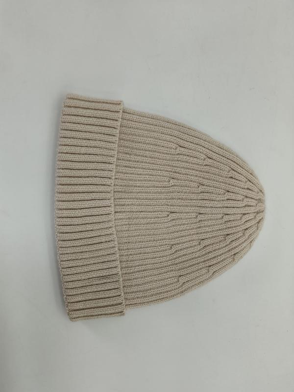 Cream ribbed knit beanie hat with folded cuff laid flat on white background, showing fine rib texture