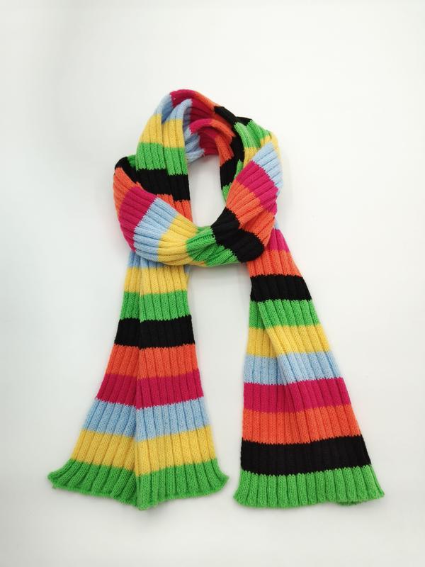Ribbed knit scarf with bold multicolor stripes in green, yellow, orange, pink, blue, and black, looped on white background