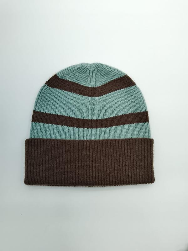 Flat lay of a mint green and dark brown striped knit beanie with ribbed cuff on white background