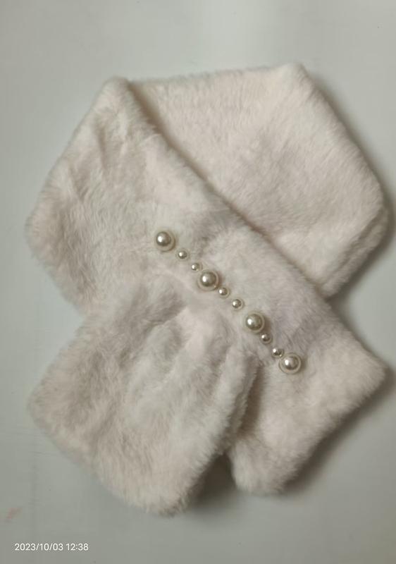 White plush faux fur crossover neck scarf with decorative pearl buttons arranged diagonally on soft fuzzy fabric