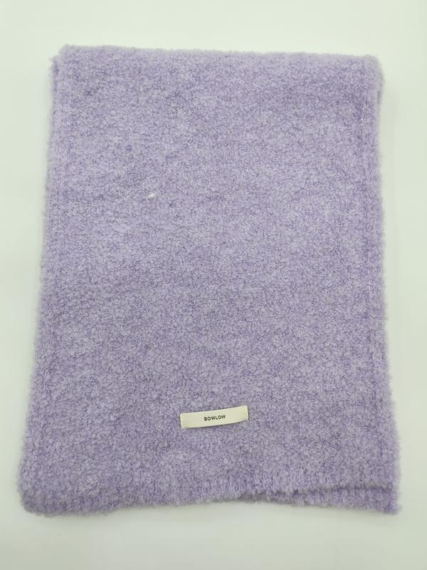 Folded lavender purple boucle texture soft throw blanket with small label on white background