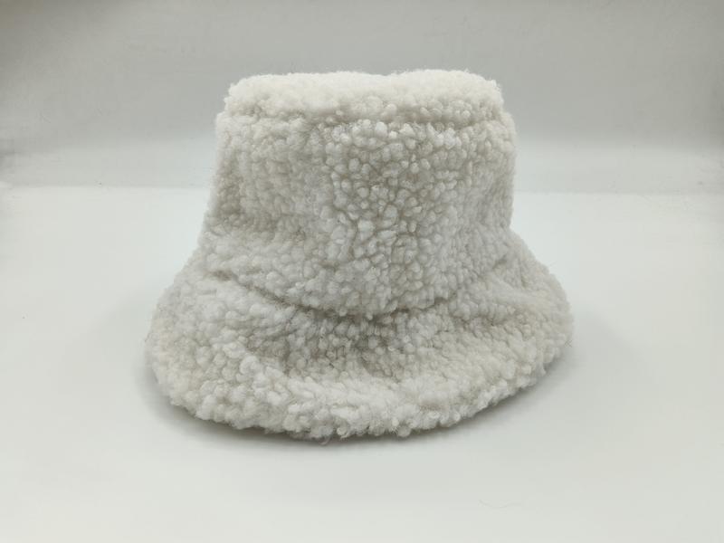 White fluffy sherpa bucket hat with wide brim and teddy fleece texture on white background