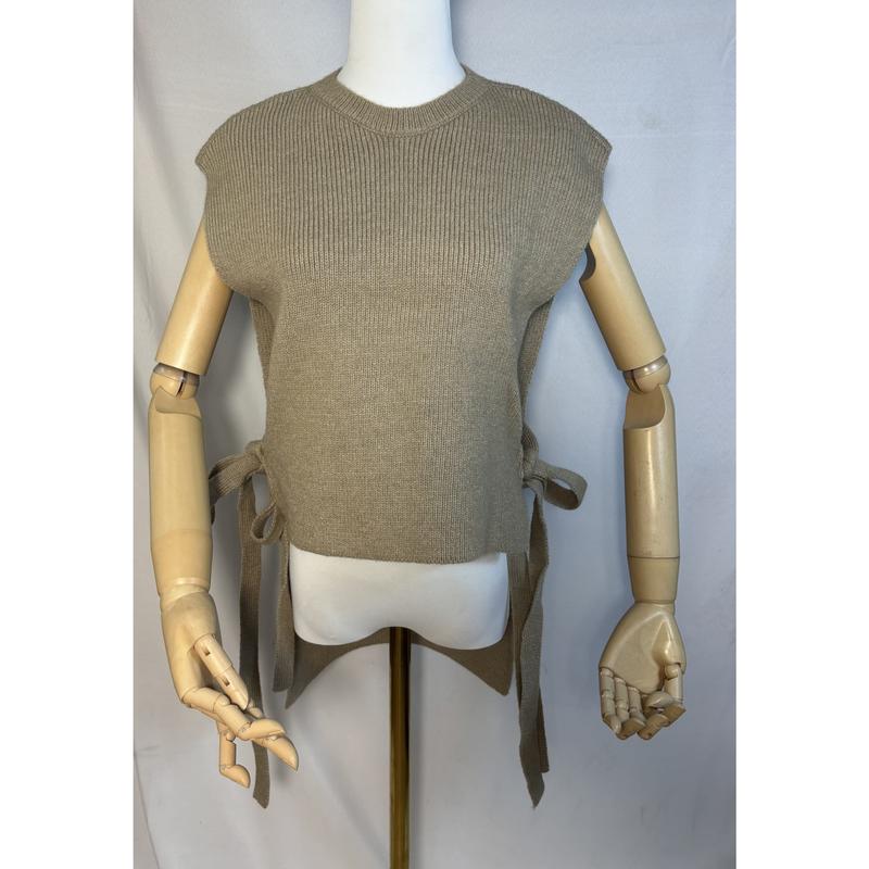 Beige ribbed knit sleeveless sweater vest with side tie bows displayed on a mannequin with wooden articulated arms