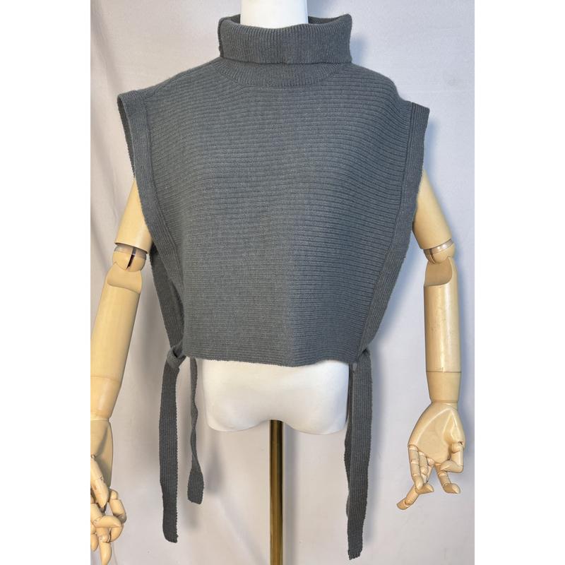 Grey ribbed knit sleeveless turtleneck sweater vest with side tie closures displayed on a wooden mannequin