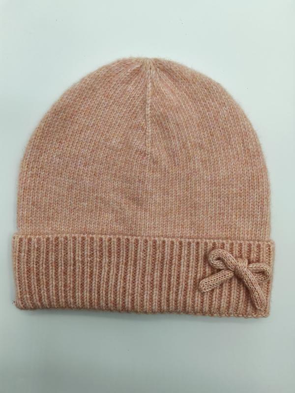 Blush pink marl knit beanie hat with ribbed cuff and small bow accent, laid flat on light background