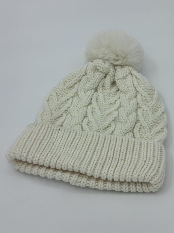 Cream white cable knit winter beanie hat with fluffy pom pom on top and double ribbed fold-up cuff
