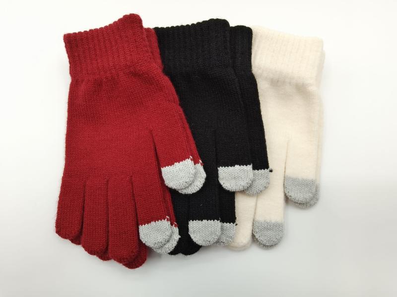 Three pairs of ribbed knit winter gloves in red, black, and cream with grey conductive fingertips for touchscreen use, laid flat on white background