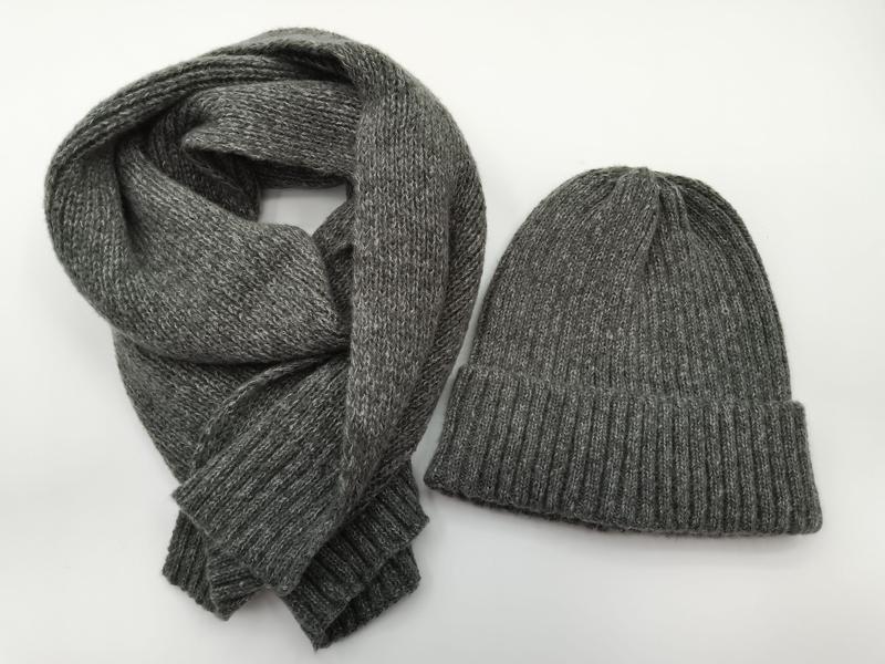Heather grey ribbed knit beanie hat and matching long knit scarf set laid flat on white background