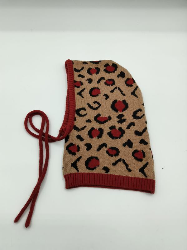 Knitted balaclava hood in beige with red and black leopard print pattern, red ribbed trim and adjustable tie strings