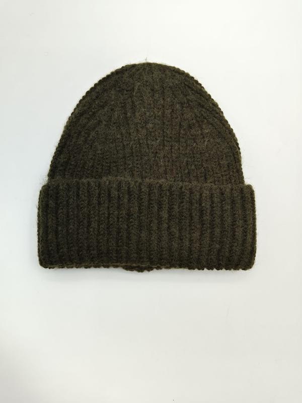 Olive green chunky ribbed knit beanie hat with folded cuff, laid flat on white background